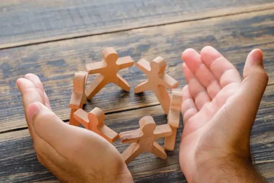 Hands holding wooden figures